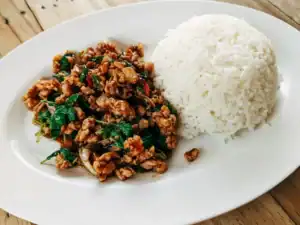 Pad Grapao Thailändisches Hackfleischgericht auf einem Teller mit Reis