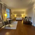 Gemütliches Hotelzimmer im Schloss Krugsdorf mit klassischen Möbeln, weichen Vorhängen und warmem Licht.